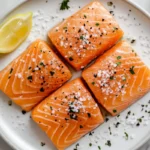 A beautifully presented plate of salmon crudo with visible olive oil and sea salt.